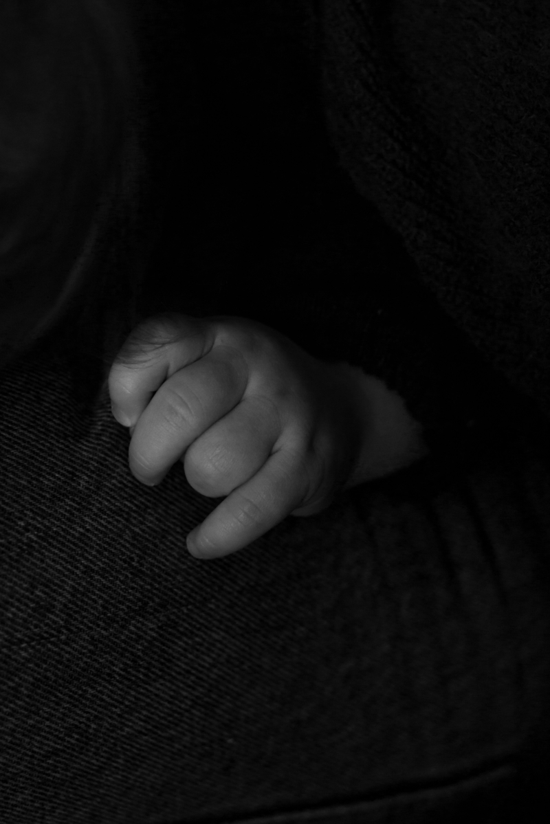 La main de loup, posé contre sa maman pour les détails d'une séance maternité intimiste